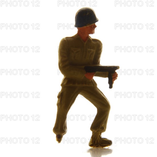 A detailed soldier figurine stands confidently, holding a weapon, set against a bright background. The scene captures the essence of imaginative play and military representation