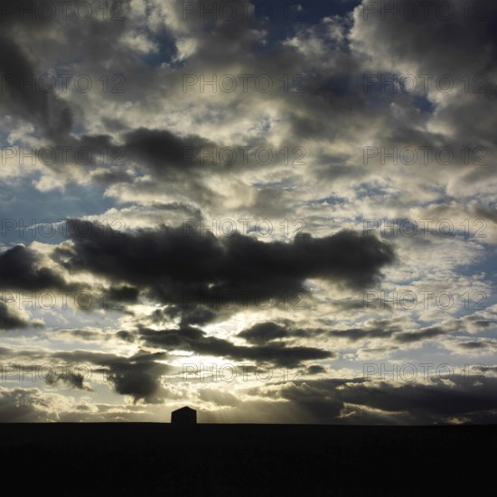A stunning display of clouds fills the sky above rural as the sun sets, casting shadows over the picturesque surroundings. The atmosphere is both serene and captivating. Puy de Dome. Auvergne Rhone Alpes. France