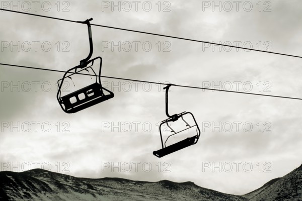 Chairlift ascends over the mountainous landscape in Auvergne, France, highlighting winter recreation opportunities for visitors