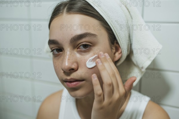 Teenage girl applying skin cream in bathroom. Honest daily skincare and self-care routine. Generative ai, AI generated