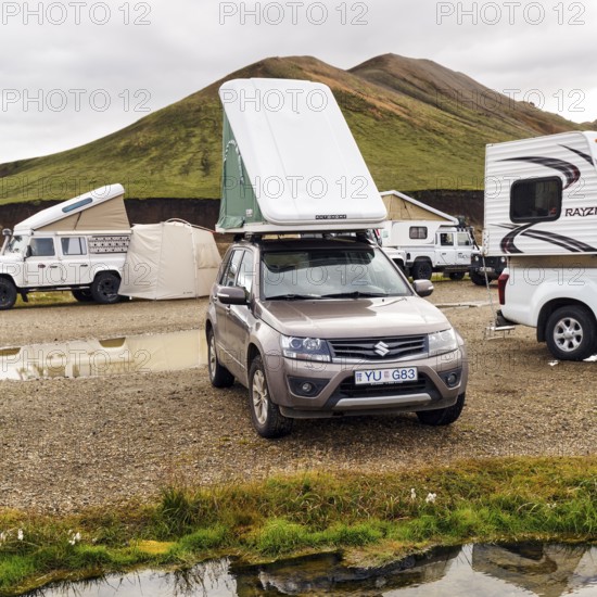 Off-road vehicle, SUV with roof tent, camping site in Landmannalaugar, Icelandic highlands, rain clouds, Suðurland, Sudurland, Iceland