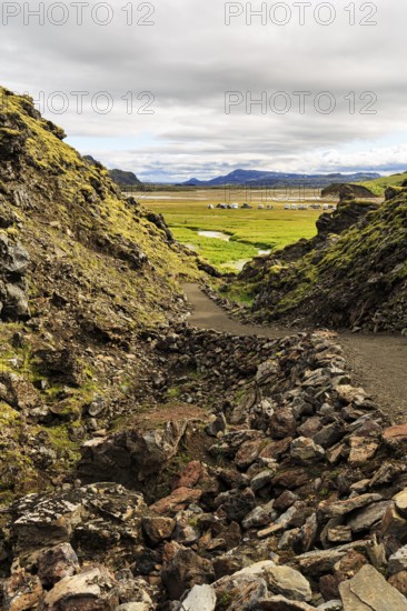 Hiking trail through volcanic landscape, lava rock, view of the campsite in Landmannalaugar, Icelandic highlands, Suðurland, Sudurland, Iceland