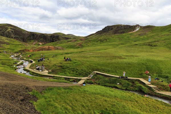 Tourists, hikers bathing in a geothermally heated river, Reykjadalur bathing area, Hveragerði, Hveragerdi, Golden Circle, Ring Road, Iceland