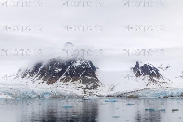 Ice in front of glacier tongue, sea, mountain peak, Smeerenburgbreen, Spitsbergen, Svalbard
