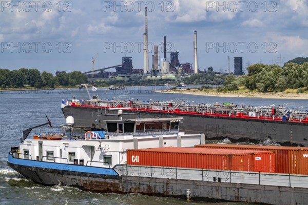 Industrial backdrop of the ThyssenKrupp Steel steelworks in Duisburg-Bruckhausen, cargo ships on the Rhine, blast furnaces, Schwelgern coking plant, Duisburg, North Rhine-Westphalia, Germany