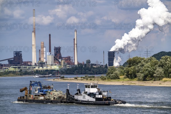 Industrial backdrop of the ThyssenKrupp Steel steelworks in Duisburg-Bruckhausen, cargo ship on the Rhine, work ship Westfalia, blast furnaces, Schwelgern coking plant, extinguishing cloud, Duisburg, North Rhine-Westphalia, Germany