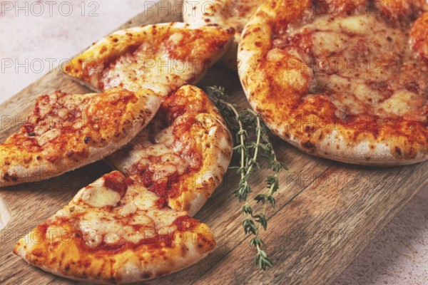 Four pizzetta Margaritas, on a cutting board, on a light gray surface, top view
