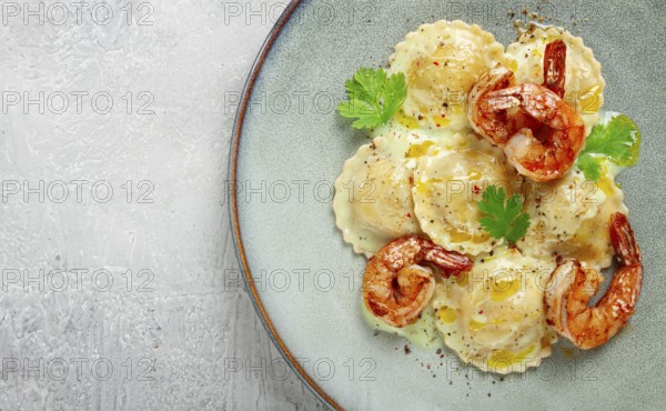 Ravioli with shrimp, in cream sauce, with spices and herbs, top view, no people