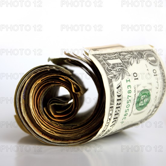 A rolled banknote rests on a clean surface, highlighting the details of the bill and its unique features. The currency appears worn yet valuable, hinting at its history and stories