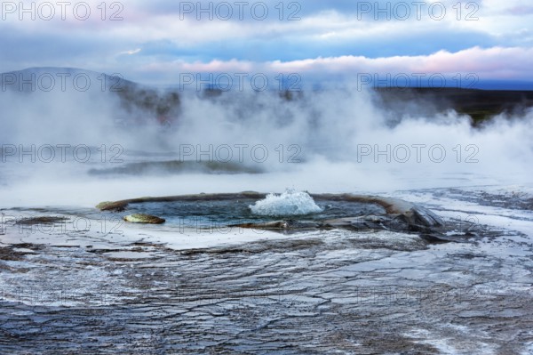 Sinter terraces with geyser, sulphur vapour, evening sky, Hveravellir geothermal area, Icelandic highlands, Suðurland, Sudurland, Iceland
