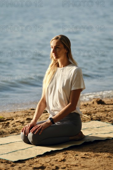 A woman sits calmly on a yoga mat by the water, practicing mindfulness as the sun sets. The serene environment creates a perfect atmosphere for relaxation and meditation near the lake