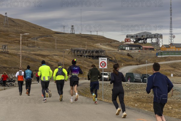 Marathon, group of runners in front of the historic Taubanestralen cable car, transport cable car, coal distribution cable car, Longyearbyen, Spitsbergen, Svalbard