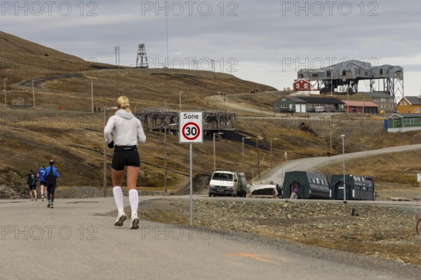 Marathon, runner in front of the historic Taubanestralen cable car, transport cable car, coal distribution cable car, Longyearbyen, Spitsbergen, Svalbard