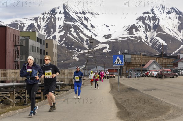 Marathon, group of runners along the city centre, Snow Mountain, Longyearbyen, Spitsbergen, Svalbard