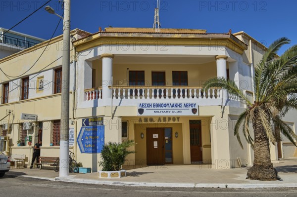 Military club building with columns and palm trees in a street scene, Armando Bernabiti, Historicism, Rationalism, Art Deco, Rationalism, Rodolfo Petraco, Fascism, Portolago, Lakki, Leros, Dodecanese, Greek Islands, Greece