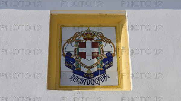 Fascist Italian coat of arms, A mural with a coat of arms showing a cross, a crown and banners in a yellow border, Armando Bernabiti, Historicism, Rationalism, Art Deco, Rationalism, Rodolfo Petraco, Fascism, Portolago, Lakki, Leros, Dodecanese, Greek Islands, Greece