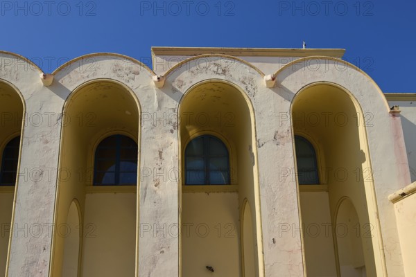 Primary school, Beige-coloured façade with arched windows against a clear sky, Armando Bernabiti, Historicism, Rationalism, Art Deco, Rationalism, Rodolfo Petraco, Fascism, Portolago, Lakki, Leros, Dodecanese, Greek Islands, Greece