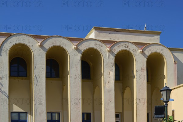 Primary school, Beige-coloured building with large arches against a clear blue sky, Armando Bernabiti, Historicism, Rationalism, Art Deco, Rationalism, Rodolfo Petraco, Fascism, Portolago, Lakki, Leros, Dodecanese, Greek Islands, Greece