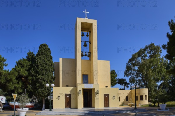 Church of Saint Francis, Church of Saint Nicholas, Agios Nikolaos, Yellow church with bell tower and cross surrounded by trees, Armando Bernabiti, Historicism, Rationalism, Art Deco, Rationalism, Rodolfo Petraco, Fascism, Portolago, Lakki, Leros, Dodecanese, Greek Islands, Greece