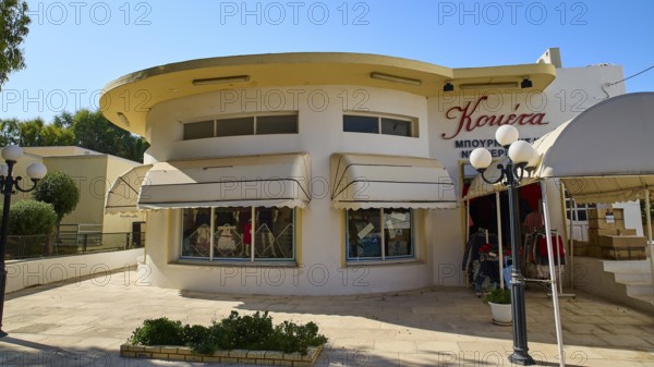 A building with a round façade and large shop windows, sun protection marked, Armando Bernabiti, Historicism, Rationalism, Art Deco, Rationalism, Rodolfo Petraco, Fascism, Portolago, Lakki, Leros, Dodecanese, Greek Islands, Greece