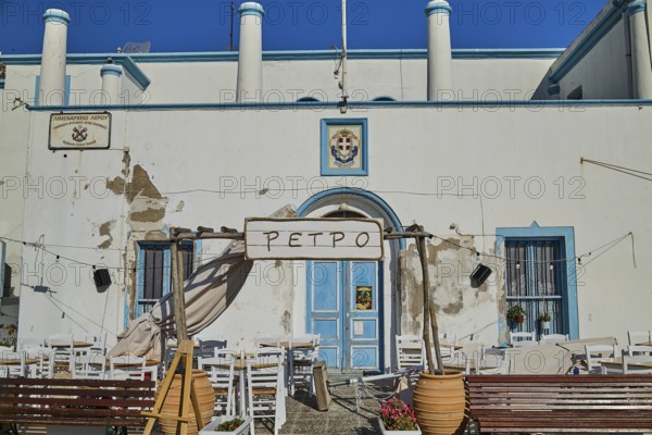 Harbour Authority building, Mediterranean café with white chairs and blue window on a sunny day, Armando Bernabiti, Historicism, Rationalism, Art Deco, Rationalism, Rodolfo Petraco, Fascism, Agia Marina, Leros, Dodecanese, Greek Islands, Greece