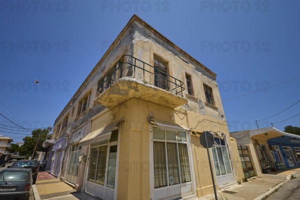 Persiana, Old building with worn façade and small balcony on a street corner, Armando Bernabiti, Historicism, Rationalism, Art Deco, Rationalism, Rodolfo Petraco, Fascism, Portolago, Lakki, Leros, Dodecanese, Greek Islands, Greece