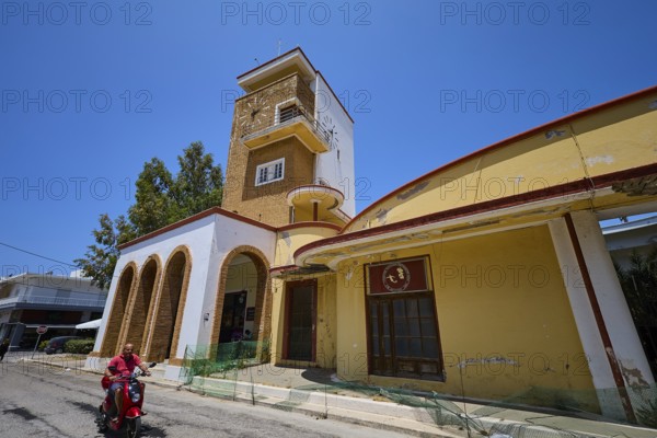 Market hall, Agora, Historical building with clock tower and arches, animated by people and trees along a street, Armando Bernabiti, Historicism, Rationalism, Art Deco, Rationalism, Rodolfo Petraco, Fascism, Portolago, Lakki, Leros, Dodecanese, Greek Islands, Greece