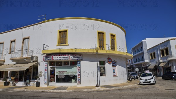 White corner building with shops and parked cars on the street, Armando Bernabiti, Historicism, Rationalism, Art Deco, Rationalism, Rodolfo Petraco, Fascism, Portolago, Lakki, Leros, Dodecanese, Greek Islands, Greece