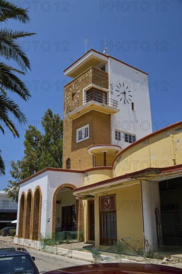 Market hall, agora, clock tower in yellow and red with palm trees and arches, embedded in a green environment, Armando Bernabiti, historicism, rationalism, art deco, rationalism, Rodolfo Petraco, fascism, Portolago, Lakki, Leros, Dodecanese, Greek Islands, Greece