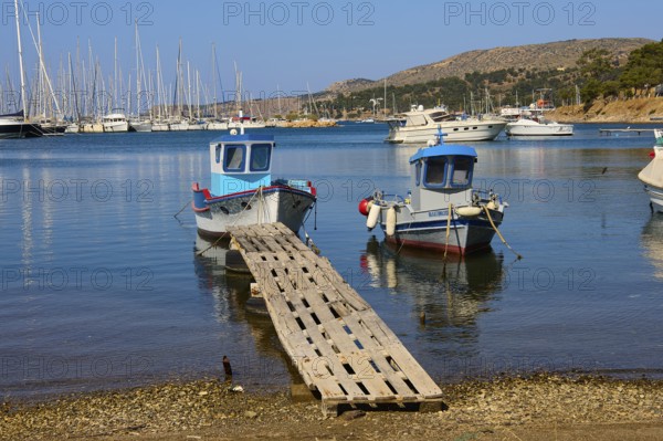 Small boats and sailing boats in a quiet, clear harbour, Lakki, Leros, Dodecanese, Greek Islands, Greece