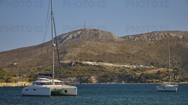 Two sailing boats on a calm sea, with barren hills in the background, Lakki, Leros, Dodecanese, Greek Islands, Greece