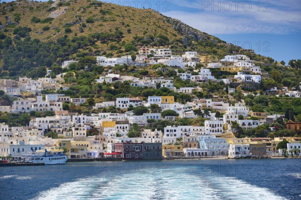 Coastal town with colourful houses on a hill, sea waves in the foreground, Lakki, Leros, Dodecanese, Greek Islands, Greece