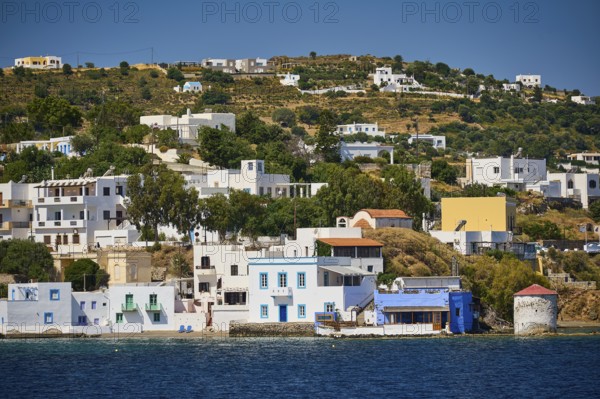 White-blue houses along the coast in front of a green hill, Lakki, Leros, Dodecanese, Greek Islands, Greece
