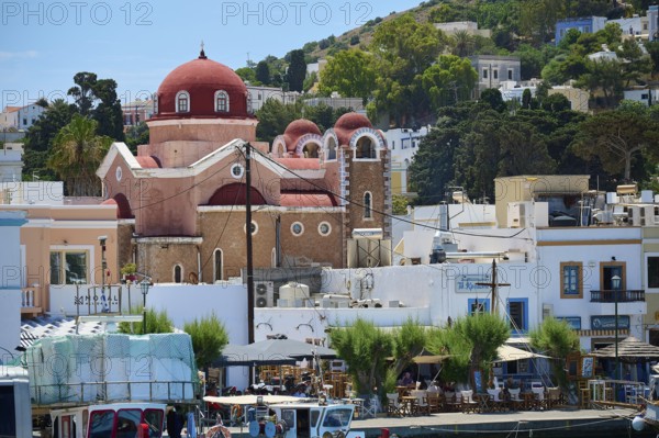 Church with red domes in a lively harbour town surrounded by boats, Lakki, Leros, Dodecanese, Greek Islands, Greece