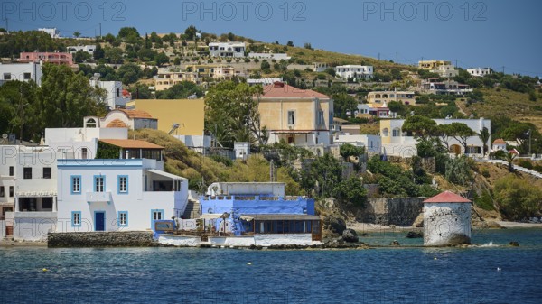 Coastline with mill and typical Greek houses on the blue water, Lakki, Leros, Dodecanese, Greek Islands, Greece