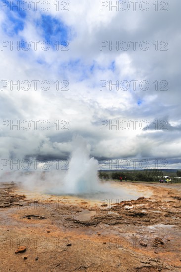 Active Strokkur, tourists watch eruption, high temperature area Haukadalur, tourist attraction at the Golden Circle, Sudurland, Iceland