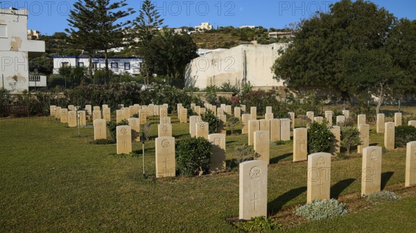 An extensive war cemetery with gravestones, surrounded by trees and a hilly landscape under a blue sky, Military Cemetery, Commonwealth War Cemetery, Military Cemetery, WW2, 1939-1945, 179 graves, Alinda, Leros, Dodecanese, Greek Islands, Greece