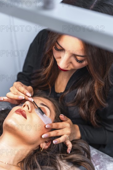 Beautician carefully applying eyelash extensions to a client, enhancing her natural beauty in a professional salon environment