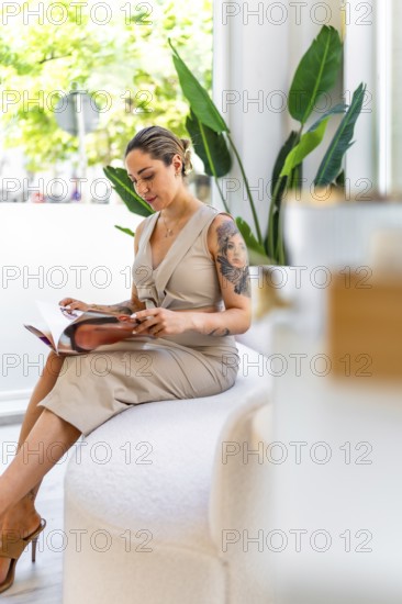 Young woman reading a magazine while waiting in a beauty salon, enjoying the relaxing atmosphere and anticipating her treatment