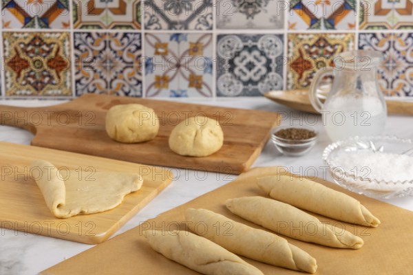 Preparation of pretzel sticks, different stages of the dough surrounded by ingredients
