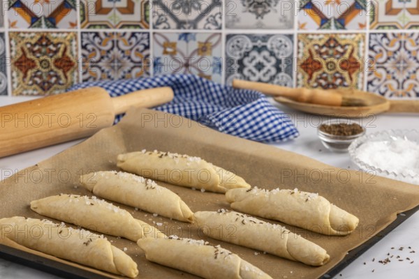 Sprinkle the raw salt sticks with salt and caraway seeds on a baking tray