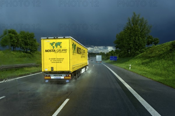 Overtaking manoeuvre of articulated lorry, lorry overtaking in thunderstorm, heavy rain, poor visibility, black sky, aquaplaning, A9 motorway near Pfaffenhofen, Upper Bavaria, Bavaria, Germany