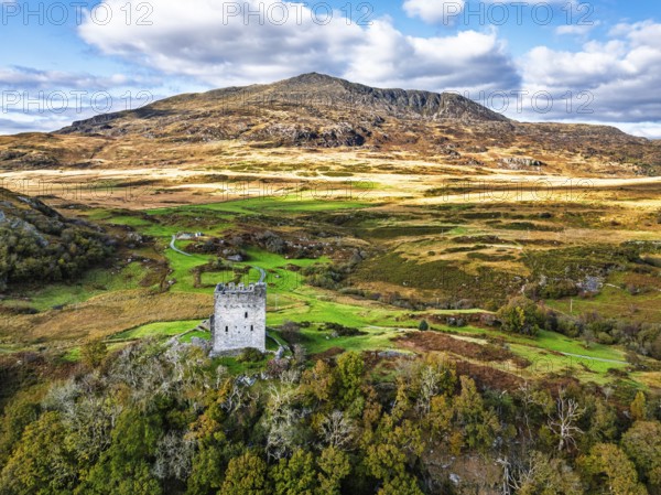 Autumn colours over Castell Dolwyddelan and Eryri Mountains from a drone, Snowdonia, Conwy County Borough, Wales, England, United Kingdom