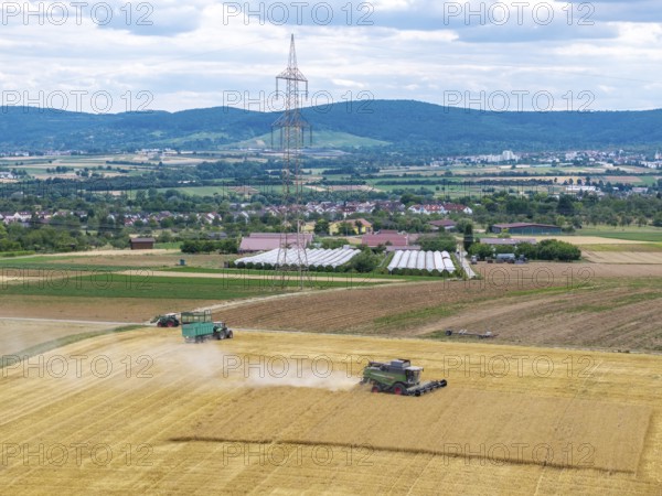 Harvesters and tractors in a field under a blue sky in a mountainous landscape, Korb im Rems Valley, Baden-Württemberg, Germany
