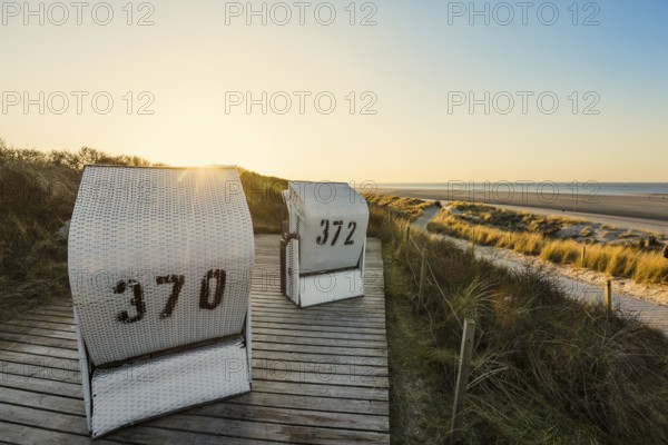 Beach chairs in the dunes and blue sky in winter, sunset, Spiekeroog, East Frisian Islands, Lower Saxony, Germany