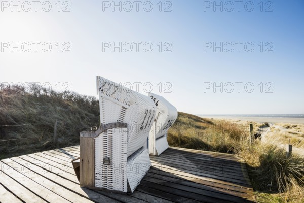 Beach chairs in the dunes and blue sky in winter, Spiekeroog, East Frisian Islands, Lower Saxony, Germany