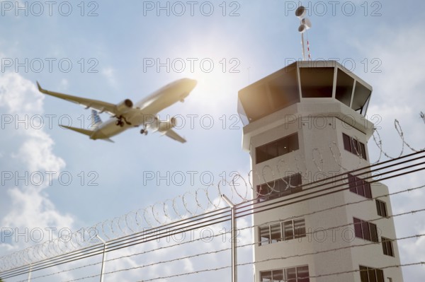 Air traffic control tower at airport as airplane takes off