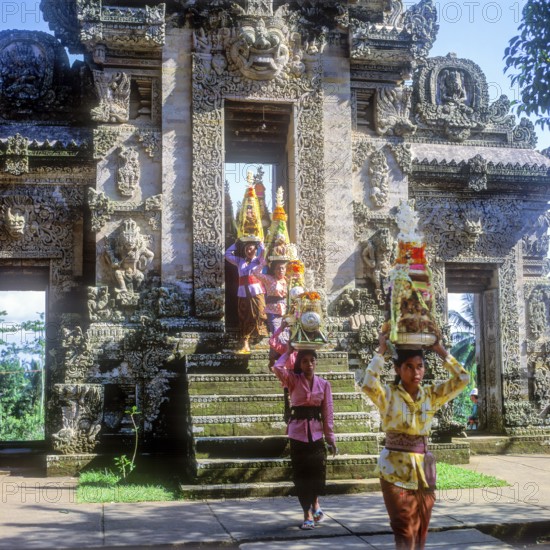 Temple festival, woman wearing traditional costumes, Gebogan, offerings piled up up to pyramids, are carried into the temple Pura Kehen in Bangli for ceremonies in the temple, Bangli, Bali, Indonesia