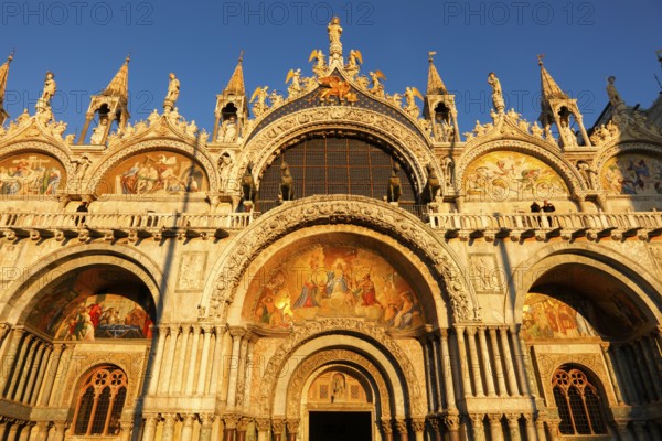 Warm glow of the setting sun on the detailed architecture of the Basilica San Marco in Venice, Veneto, Italy