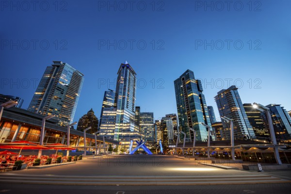 Illuminated skyscrapers on the promenade in the evening, Olympic Cauldron Statue, Jack Poole Plaza Square, Blue Hour, Coal Harbour, Vancouver, British Columbia, Canada